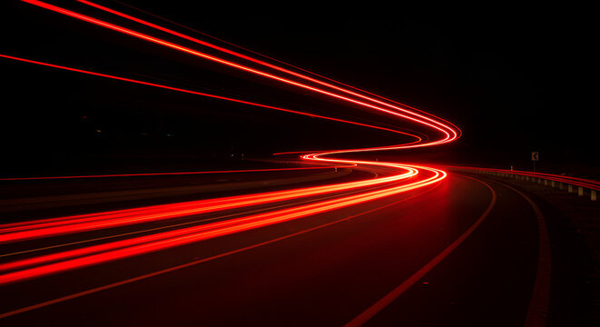 Night road with long exposure showing red light trails of passing vehicles