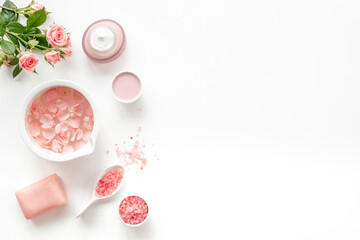 Spa organic cosmetic products with roses essential oil on white background top view