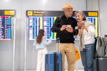 Senior asian couple sitting with luggage checking passport planning trip showing travel preparation...