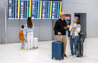Senior asian couple sitting with luggage checking passport planning trip showing travel preparation...