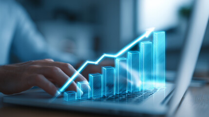 Person using laptop with rising bar graph overlay showing financial growth and business success concept