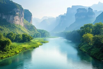 Serene river flowing through lush green valleys, with majestic mountains in the background under a soft, hazy sky.