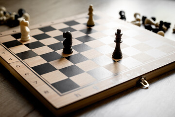 White and black chess pieces on chessboard during the game, close up