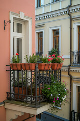 Ornate balcony overflowing with colorful flowers.
