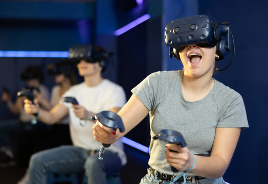 Female teenager in virtual reality headset with joystick in hands play network survival game in stone jungle of future. concept of altered reality.Immersive Technologies XR VR AR MR
