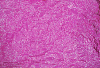 Fototapeta premium Close-up fragment of a pink magenta crumpled paper texture as a backdrop composition. Crumpled pink paper texture background