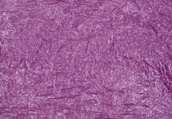 Close-up fragment of a purple crumpled paper texture as a backdrop composition. Crumpled purple paper texture background
