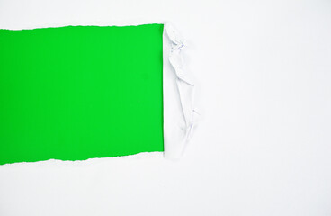 Torn white paper cutout material is displayed on a plain green background, creating an abstract design that explores the theme of design and texture suitable for advertising, banners. Torn white paper