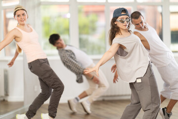Girl makes movements and teaches group of hip hop fans to move beautifully and confidently to...