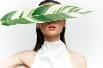A woman with a leaf covering her eyes symbolizes mystery and nature, displaying a serene expression...