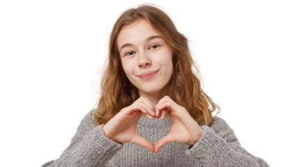Young woman making a heart shape with her hands, smiling, wearing a cozy sweater, isolated on white background.