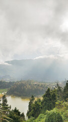 Misty Mountain Lake Landscape with Lush Greenery and Sunlight Rays
