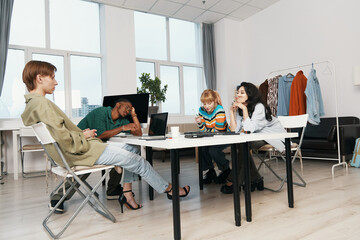 Young adult business colleagues socializing in modern workplace, Gen Z coworkers working together,...