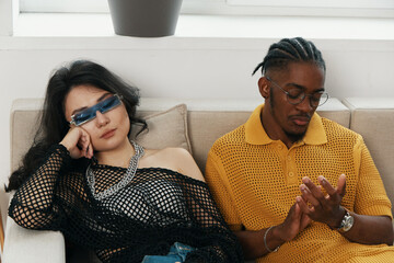 Young adult man working and woman socializing together in a modern workplace, representing Gen Z...