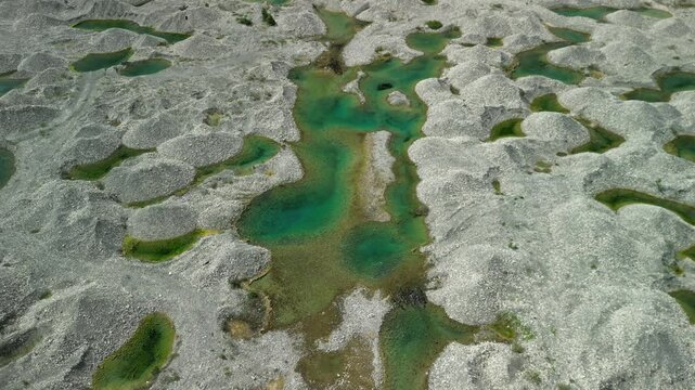 High‑altitude pullback exposes the whole lagoon network of green pools and ash‑tone sand&mdash;great for destination teasers or inspo reels.
