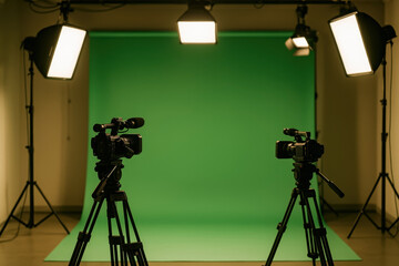 Professional video studio with green screen, lighting equipment and two cameras set for production shoot