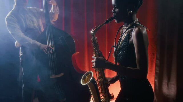 Side view shot of glamorous Black woman playing saxophone on stage while performing in vintage jazz club, copy space