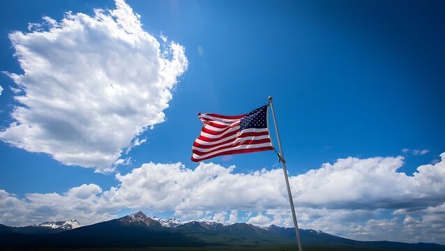 American Flag Waving under a Bright Blue Sky with Clouds and Distant Mountains - Patriotic Outdoor Landscape