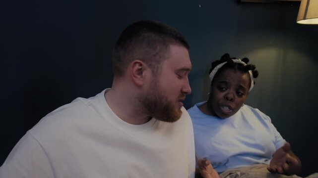 Man getting up from bed and going away during quarrel with his girlfriend at night