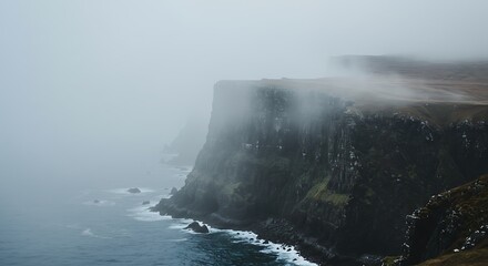 Dramatic fog rolling over a coastal cliff