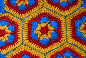 Yellow and red crochet rug. Handmade product made of woolen threads.