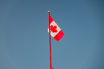 Canada Flag flagging in a withstand with blue sky in the background