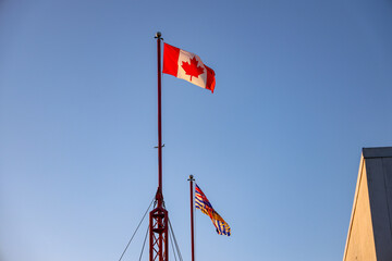 Canada Flag flagging in a withstand with blue sky in the background