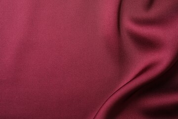 Crumpled burgundy silk fabric as background, top view