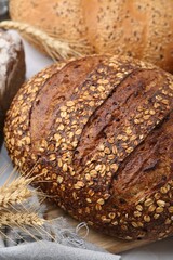 Fresh bread loaves and spikes on white table, closeup