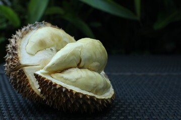 Fresh ripe durian on wicker table outdoors, closeup. Space for text