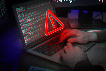 Cyber attack alert notification. Red warning sign on virtual screen. Hacker using laptop, closeup