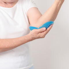 Elderly Woman having elbow ache and Edema with Cold Gel pack  for concepts of Tennis Elbow, muscle...