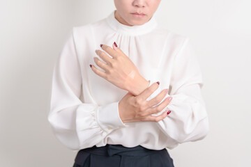 Woman having wrist pain with Medicated pain relief patch plaster for Carpal Tunnel Syndrome, Wrist...
