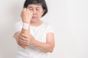 Elderly Woman having wrist pain with Medicated pain relief patch plaster for Carpal Tunnel...