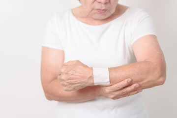 Elderly Woman having wrist pain with Medicated pain relief patch plaster for Carpal Tunnel...