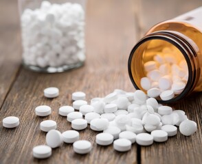 White Pills Spilled from Amber Bottle on Wooden Surface