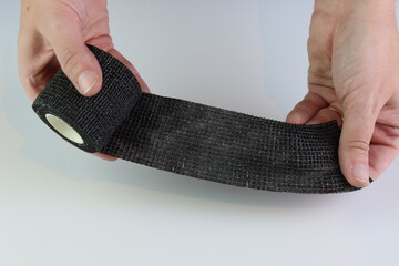 Black cohesive bandage beeing stretched
