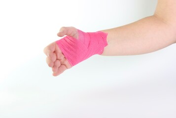 Woman hand with a pink cohesive bandage isolated in a white background