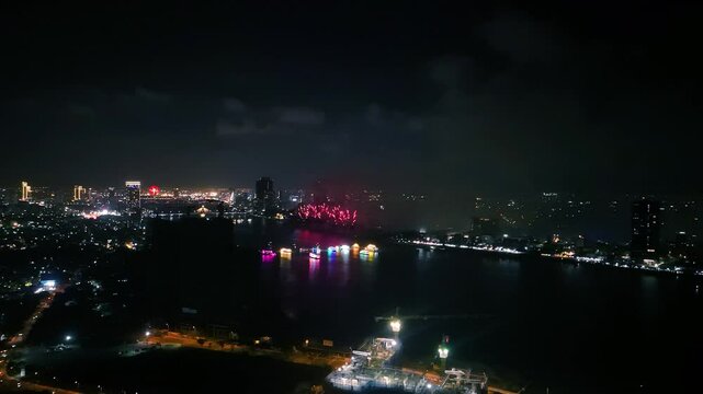 Vibrant fireworks bursting across night sky, illuminating da nang cityscape and reflecting over han river, capturing festive urban landscape of vietnam