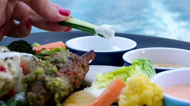 dip a piece of cucumber into the sauce. High quality 4k footage