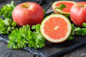 Fresh apples and grapefruit on a slate board with parsley