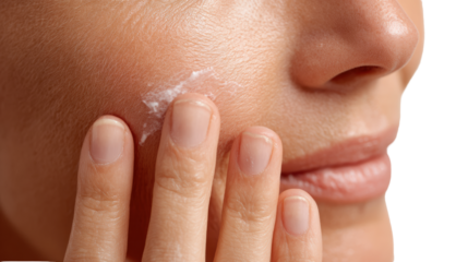 Close-up of a woman applying moisturizer to her facial skin for skincare routine.