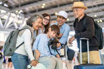 Asian multigenerational family at airport traveling with kids and grandparents, joyful moments of vacation, family holiday trip with luggage before flight, tour, friendly airline, hotel for families