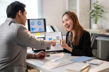 A man and a woman are sitting at a desk with a presentation in front of them