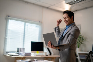 Obraz premium A man in a suit is holding a laptop and smiling