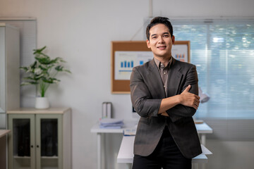 Fototapeta premium A man in a suit stands in front of a white board with graphs on it