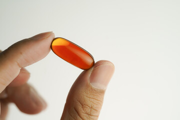 Male hand holding Oil filled capsules, softgel of food supplements, fish oil, omega 3, vitamin E
