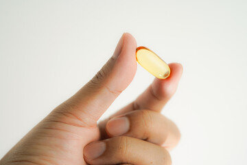 Male hand holding Oil filled capsules, softgel of food supplements, fish oil, omega 3, vitamin E