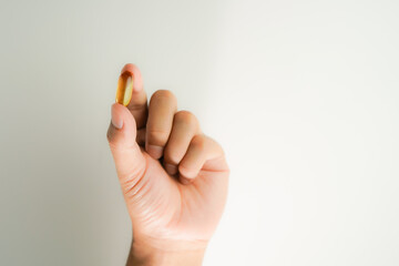 Male hand holding Fish oil capsules with omega 3, omega 9, vitamin D, vitamin E, Cod liver oil