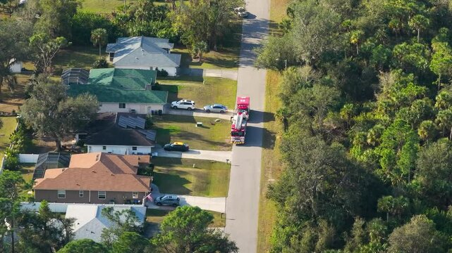 Lights from fire engine and ambulance during home medical emergency. Drone point of view.
